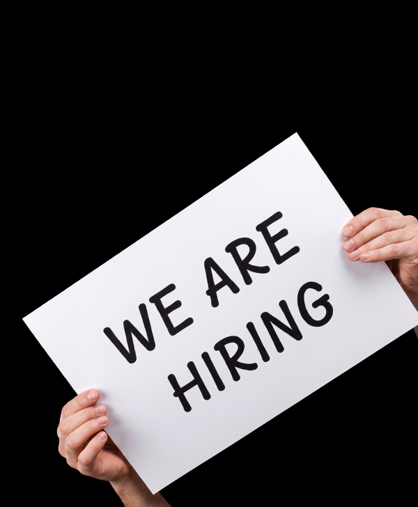 Hands holding a sign that reads: We are hiring